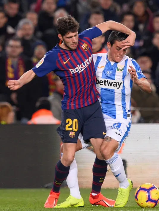 Gelandang Barcelona, Sergi Roberto berebut bola dengan bek Leganes, Jonathan Silva pada pertandingan pekan ke-20 La Liga Spanyol, di Camp Nou, Senin (21/1). Barcelona kian kokoh di puncak klasemen usai menang 3-1 atas Leganes. (Josep LAGO / AFP)