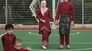 Dinda Hauw dan Rey Mbayang tampil kompak mengenakan baju maroon khas melayu bersama kedua anaknya. Dinda mengenakan baju tunik dan rok warna senada. [@dindahw]