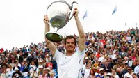Petenis Britania, Andy Murray, mengangkat trofi usai mencetak rekor lima kali juara turnamen pemanasan Wimbledon, Aegon Championships, Minggu (19/6/2016). (Bola.com/Twitter/ATPWorldTour)