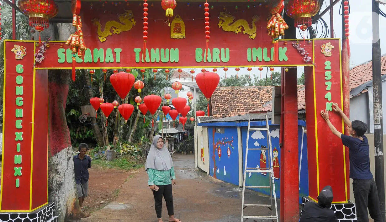 Warga memasang lampion dan menghias gapura dengan pernak-pernik imlek di Kampung Haji Bona, Depok, Jawa Barat, Kamis (19/1/2023). Bagi masyarakat Tionghoa, Imlek merupakan hari raya yang dirayakan sangat meriah oleh masyarakat keturunan China di seluruh dunia. (merdeka.com/Arie Basuki)