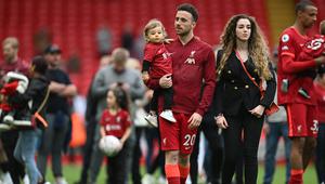 Diogo Jota menggendong anak beserta istrinya di Stadion Anfield pada laga terakhir Liverpool di Liga Inggris musim 2024/2025. (Paul ELLIS / AFP)