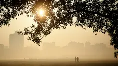 Orang-orang berjalan di pagi berkabut di taman Maidan di Kolkata (29/11/2019). Selama musim dingin, wilayah utara India sering mengalami kabut tebal, menyebabkan penundaan lalu lintas dan mengganggu jadwal penerbangan dan kereta api. (AFP Photo/Dibyangshu Sarkar)