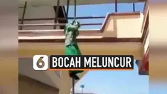 Aksi nyeleneh dilakukan seorang bocah perempuan. Ia tak menggunakan tangga untuk turun ke lantai dasar sekolahnya, melainkan meluncur dari tiang bendera.