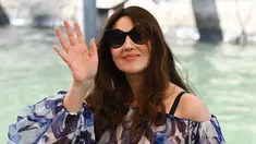 Monica Bellucci melambaikan tangan saat tiba di dermaga Palazzo del Cinema selama Venice Film Festival 2022 ke-79 di Lido di Venesia, Italia (8/9/2022). Monica Bellucci terlihat sangat chic dalam blus biru tipis dan celana hitam saat ia tiba di sesi pemotretan Siccita. (AFP/Andreas Solaro)