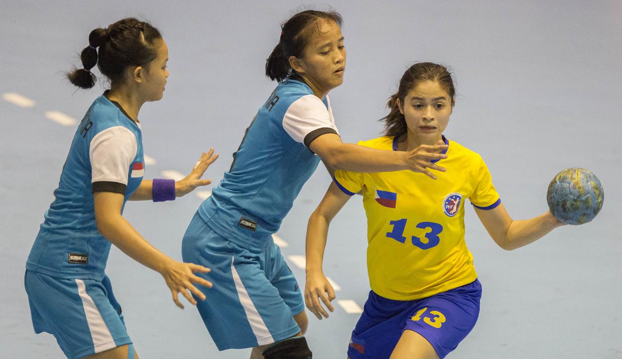 Pebola tangan putri Filipina, Dana Lora Schulte, berusaha melewati penjagaan ketat dari tim bola tangan putri Indonesia pada International Handball Federation Trophy 2016 di Jakarta, Sabtu (5/3/2016). (Bola.com/Vitalis Yogi Trisna)