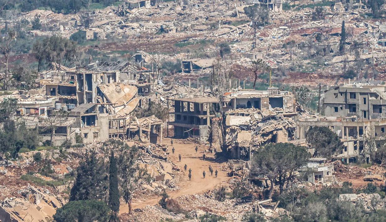 Foto menunjukkan tentara Israel berjalan di antara rumah-rumah yang hancur di Lebanon Selatan, pada Senin 27 April 2026. (Jalaa MAREY/AFP)