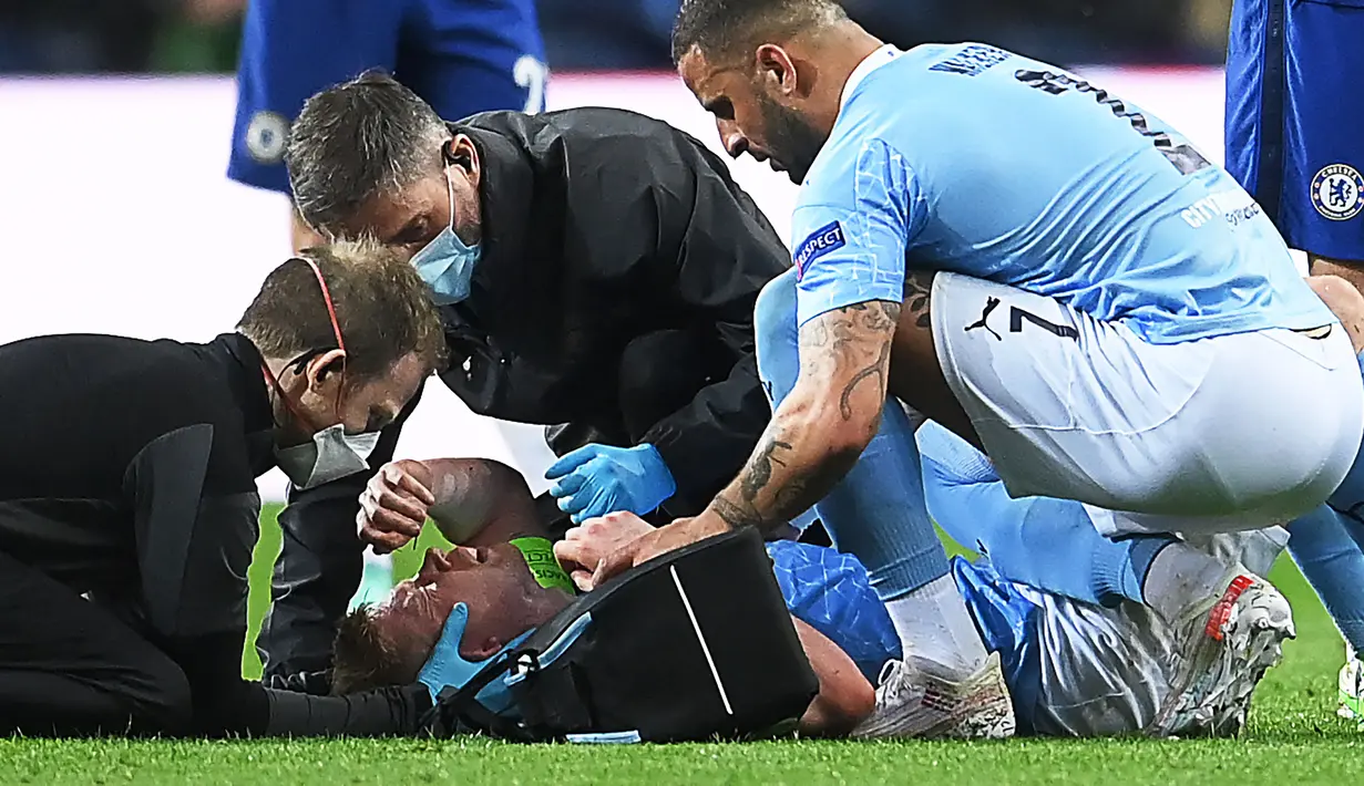 Kevin De Bruyne (tengah) mendapat perawatan medis setelah bertabrakan dengan Antonio Rudiger selama pertandingan final Liga Champions antara Manchester City dan Chelsea di Stadion Dragao di Porto, Portugal, Sabtu (29/05/2021) atau Minggu dini hari WIB. (Foto: AFP/Pool/David Ramos)