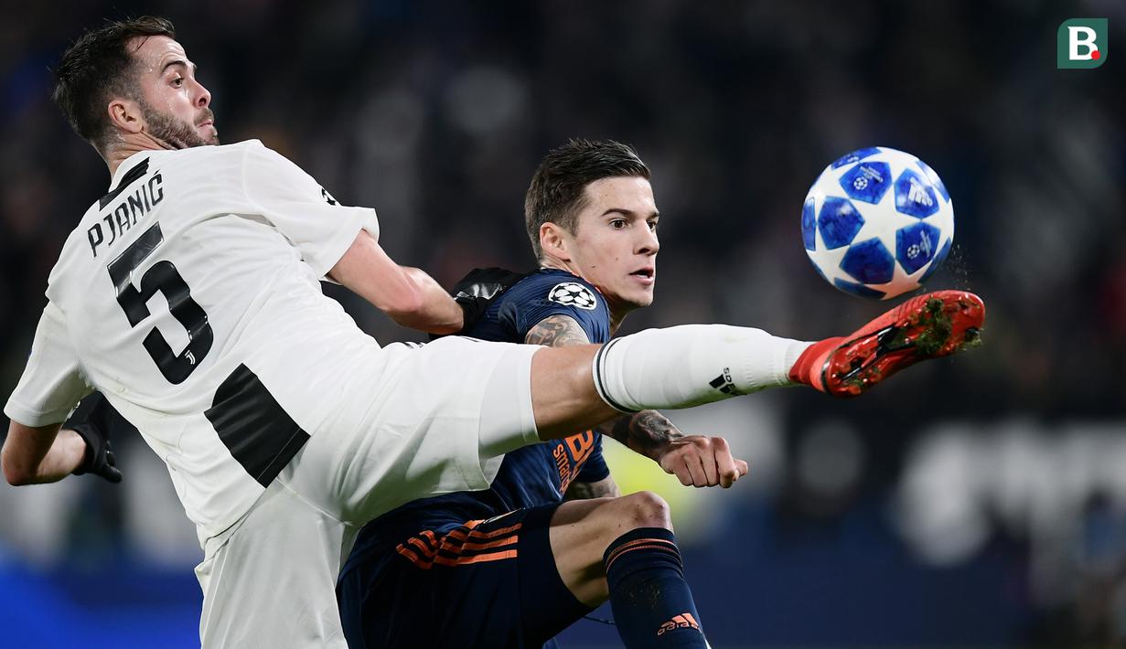 Gelandang Juventus, Miralem Pjanic, berebut bola dengan striker Valencia, Santi Mina, pada laga Liga Champions di Stadion Allianz, Turin, Selasa (27/11). Juventus menang 1-0 atas Valencia. (AFP/Marco Bertorello)