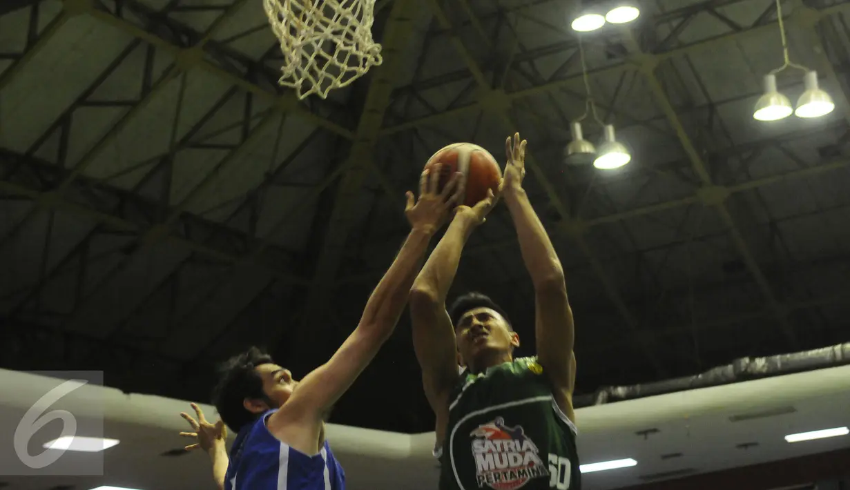Pemain Bandung Utama mencoba menghalangi serangan M Haq Dhiyatul (kanan-Satria Muda) dilanjutan Perbasi Cup 2016 di GOR Soemantri Brodjonegoro, Jakarta, Jumat (28/10). Satria Muda menang telak 86-38 atas Bandung Utama. (Liputan6.com/Helmi Fithriansyah)