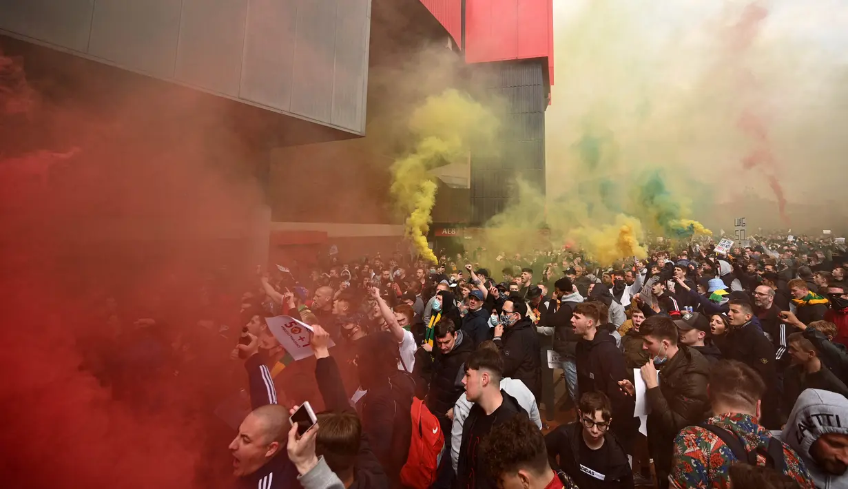 Suporter Manchester United berkumpul secara massal di luar Theatre of Dreams. Ole Gunnar Solskjaer sempat meminta mereka untuk damai. Tapi, amarah suporter tak terkendali lagi dan berkobar selama aksi tersebut. (Foto: AFP/Oli Scarff)