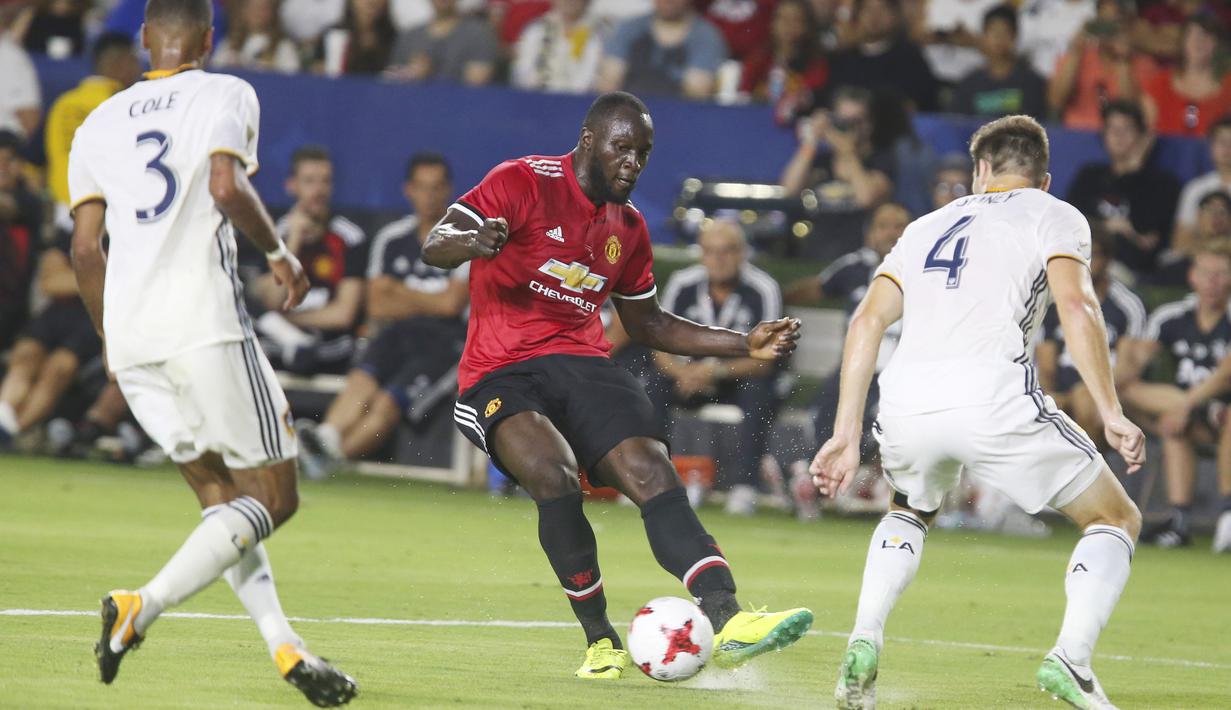 Aksi pemain Manchester United, Romelu Lukaku (tengah) melepaskan tembakan saat diadang dua pemain LA Galaxy pada laga persahabatan di California, Sabtu (15/7/2017).  (AFP/Ringo Chiu)