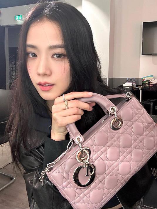 Jisoo BLACKPINK tampil kasual dengan atasan hitam dengan tas Dior Small Lady D-Joy berwarna peony pink. [Dior].