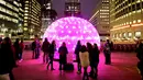 Sejumlah orang melihat seni instalasi lampu Sonic Light Bubble saat festival Canary Wharf Winter Lights di London (16/1). (Ian West / PA via AP)
