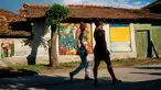 Dua orang wanita melewati lukisan mural karya seniman terkenal di dinding rumah desa Staro Zhelezare di Bulgaria, 4 Agustus 2018. Dengan populasi penduduk dibawah 500 orang, desa ini disulap menjadi galeri seni yang penuh mural. (AFP/Dimitar DILKOFF)