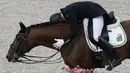 Selebrasi Joao Victor Marcari Oliva dari Brasil, memeluk kuda yang ia tunggangi usai bertanding dalam kategori Tunggang Serasi Berkuda dalam Olimpiade Tokyo 2020 di Equestrian Park, Tokyo, Sabtu (24/7/2021). (Foto: AP/Carolyn Kaster)