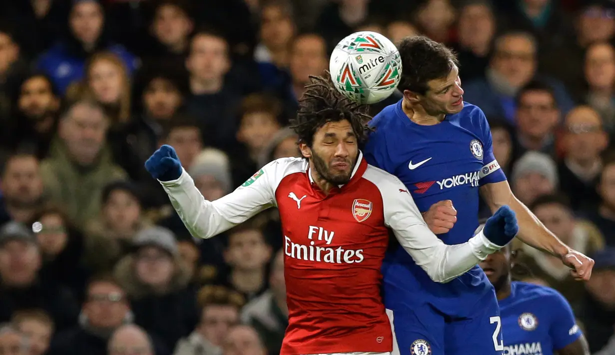 Pemain Arsenal, Mohamed Elneny melompat untuk merebut bola dari pemain Chelsea, Cesar Azpilicueta pada laga semifinal pertama Piala Liga Inggris di Stadion Stamford Bridge, Rabu (10/1). Chelsea harus puas diimbangi Arsenal 0-0. (AP/Kirsty Wigglesworth)