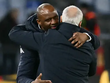Pelatih Genoa, Patrick Viera, berpelukan dengan pelatih AS Roma, Claudio Ranieri, setelah laga giornata 21 Serie A 2024/2025 yang dihelat di Olimpico, Sabtu (18/1/2025) dini hari WIB. (AFP/Filippo Monteforte)