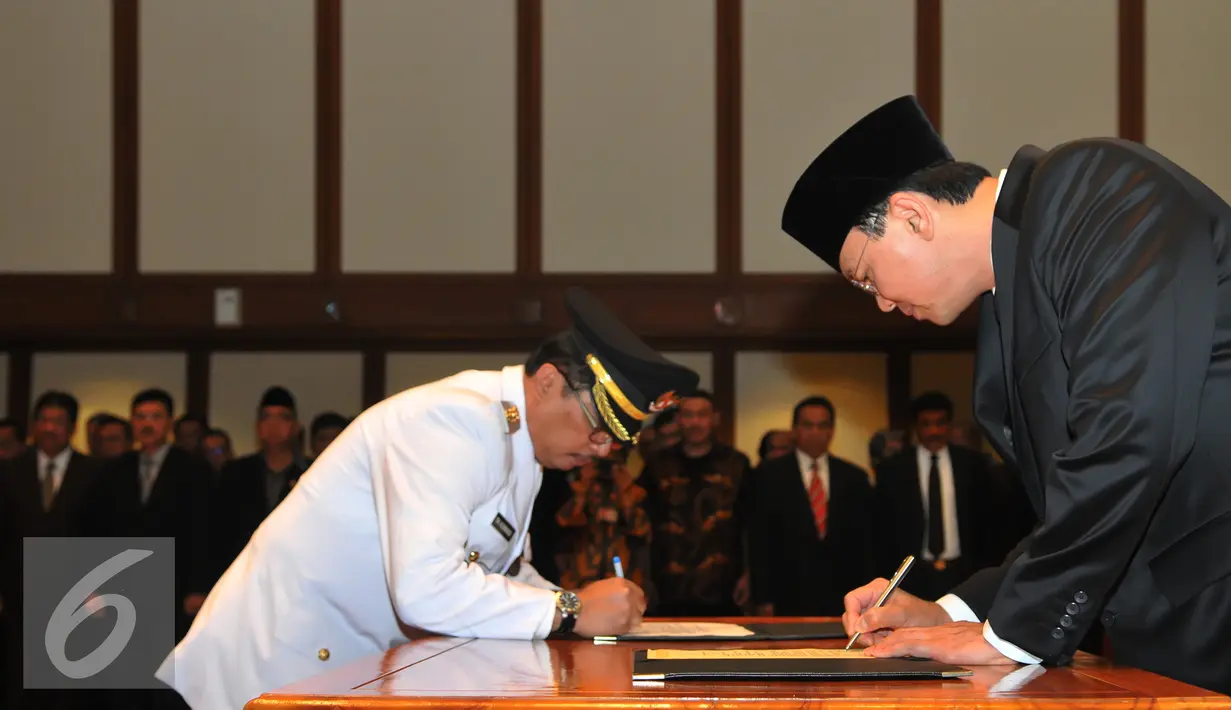 Basuki T Purnama (kanan) dan Wakil Walikota Jaksel Tri Kurniadi menandatangani dokumen saat pelantikan di balai kota, Jakarta, Kamis (13/8/2015). Tri resmi menggantikan Syamsuddin Noor yang dipecat. (Liputan6.com/Herman Zakharia)