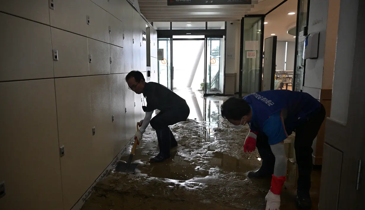 Pekerja membersihkan puing-puing dari pusat wisata setelah Topan Hinnamnor melewati Busan, Korea Selatan (6/9/2022). (AFP/Anthony Wallace)
