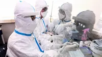 Petugas laboratorium melepaskan pakaian pelindung di sebuah laboratorium di Shenyang, provinsi Liaoning timur laut China, Rabu (12/2/2020). Per hari ini, Rabu (12/2) tercatat korban meninggal dunia akibat virus corona di China tercatat mencapai 1.110. (STR/AFP)