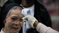 Perawat Kementerian Kesehatan Masyarakat mengukur suhu penumpang yang datang dari Prancis di Bandara Internasional Toussaint Louverture, Haiti, Selasa (4/2/2020). Virus corona menyerang pada sistem pernapasan terlebih dahulu sebelum menyerang sistem dalam tubuh lainnya. (AP Photo/Dieu Nalio Chery)