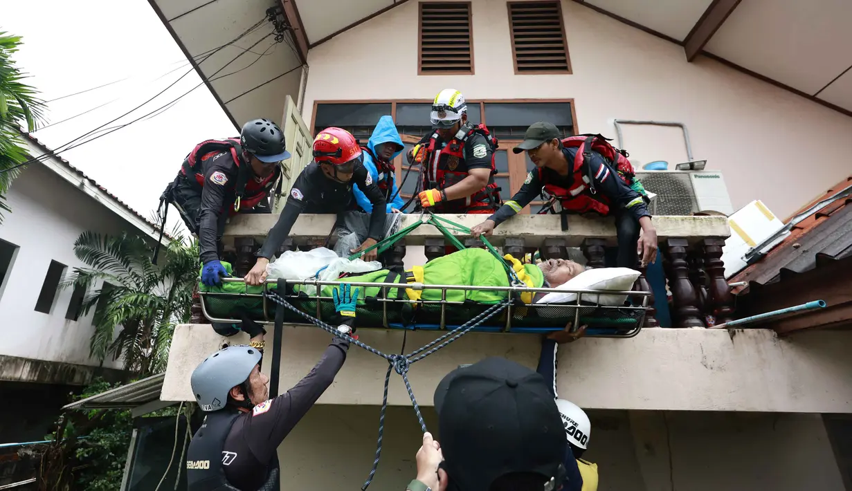 Seorang pria dievakuasi oleh tim penyelamat untuk diangkut melewati banjir di Hat Yai, Provinsi Songkhla, Thailand selatan, pada Rabu 26 November 2025. Banjir parah masih menggenangi wilayah selatan Thailand, terutama kota Hat Yai di Provinsi Songkhla hingga hari ini Rabu (26/11/2025). (Sarot Meksophawannakul/THAI NEWS PIX/AFP)
