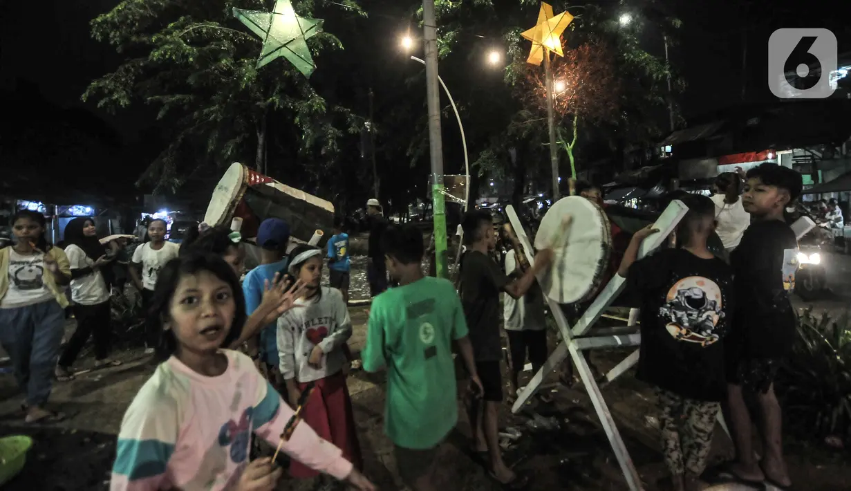 Anak-anak memainkan bedug saat merayakan malam takbiran Idul Fitri di Manggarai, Jakarta, Rabu (13/5/2021). Tradisi merayakan malam takbiran dengan memainkan bedug dan membuat hiasan bernuansa Islam masih terlihat di pinggiran Ibu Kota meski pandemi Covid-19. (merdeka.com/Iqbal S. Nugroho)