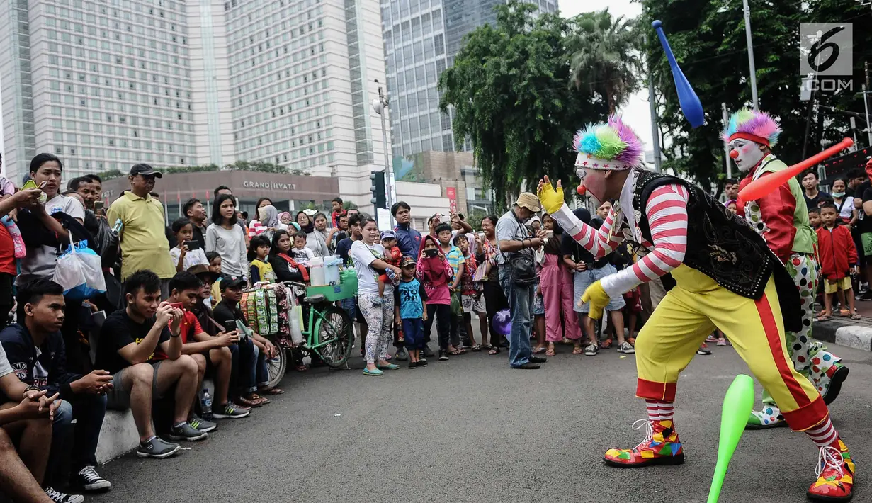 Aksi badut yang tergabung dalam Aku Badut Indonesia menghibur masyarakat saat car free day di Bunderan HI, Jakarta, Minggu (9/12). Aksi tersebut bentuk kampanye positif bertujuan mengajak masyarakat peduli terhadap sesama. (Liputan6.com/Faizal Fanani)