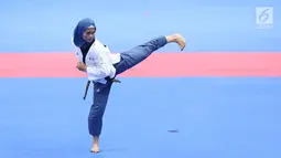 Atlet Taekwondo putri Indonesia, Defia Rosmaniar saat beraksi melawan Yun Jihye (Korea Selatan) pada Semifinal Women Individual Poomsae di JCC, Jakarta, Minggu (19/8). Defia Rosmaniar berhasil meraih emas. (Liputan6.com/Helmi Fithriansyah)