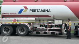 Petugas polisi memeriksa garis polisi yang terpasang di truk pengisian bahan bakar solar di SPBU Jalan Juanda, Depok, Senin (14/11). SPBU itu ditutup sementara karena salah satu pompa bahan bakar solarnya diduga bercampur air. (Liputan6.com/Yoppy Renato)
