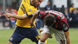 Pemain AC Milan, Hakan Calhanoglu (kanan) berebut bola dengan pemain Hellas Verona, Franco Zuculini pada lanjutan Serie A di San Siro stadium, Milan, (5/5/2018). AC Milan menang telak 4-1. (AP/Antonio Calanni)