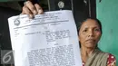 Warga Bukit Duri menunjukan Surat Peringatan (SP) 2 yang dilayangkan oleh Pemprov DKI, Jakarta, Rabu (7/9). Pemprov DKI Jakarta layangkan SP2 untuk warga Dukit Duri, Tebet terkait normalisasi kali Ciliwung. (Liputan6.com/Yoppy Renato)