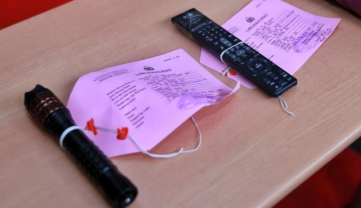 Barang bukti lainnya adalah remote teve dan senter yang sekaligus bisa dipakai buat nyetrum. Selain memukul dengan tangan kosong, remote dan senter digunakan pelaku untuk memukul korban. (Adrian Putra/Bintang.com)