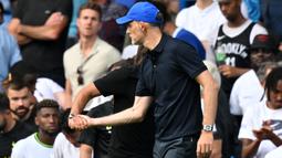 Conte pun ingin melepaskan tangannya dari genggaman Thomas Tuchel untuk menghampiri para pemain di lapangan. Namun genggaman Tuchel terlihat sangat erat sehingga Conte tidak dapat melepaskan tangannya. (AFP/Glyn Kirk)