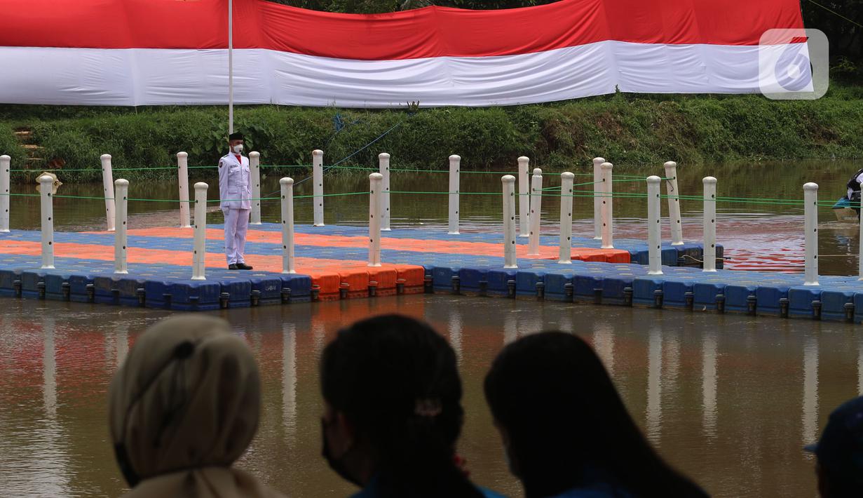 Warga saat menyaksikan pengibaran bendera merah putih di Sungai Cisadane, Kota Tangerang, Banten, Kamis (28/10/2021). Pengibaran bendera merah putih yang di ikuti puluhan pemuda tersebut di lakukan untuk memperingati hari sumpah pemuda. (Liputan6.com/Angga Yuniar)