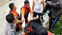 Polisi dan Basarnas Pekanbaru mengevakuasi korban terseret banjir. (Liputan6.com/M Syukur)