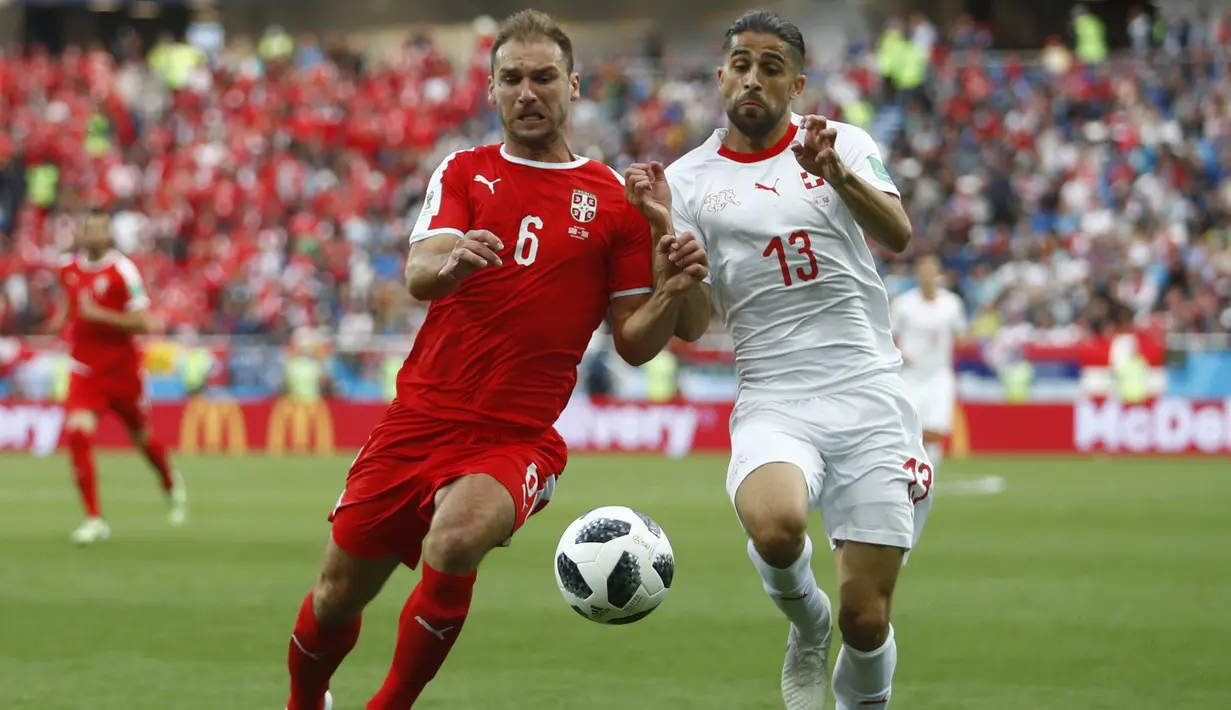 Gelandang Swiss, Michael Lang, berebut bola dengan gelandang Serbia, Milos Veljkovic, pada laga grup E Piala Dunia di Stadion Kaliningrad, Kaliningrad, Jumat (22/6/2018). Swiss menang 2-1 atas Serbia. (AP/Matthias Schrader)