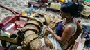 Seorang pekerja pabrik cerutu memilih daun tembakau di Havana, Kuba, Kamis (1/3). (ADALBERTO ROQUE/STR/AFP)