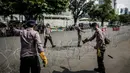 Polisi memasang kawat berduri saat aksi solidaritas untuk rakyat Palestina di Depan Kedutaan Besar Amerika Serikat, Jakarta (18/5/2021). Massa mengutuk dan mengecam keras kekerasan yang dilakukan Israel atas Palestina. (Liputan6.com/Faizal Fanani)