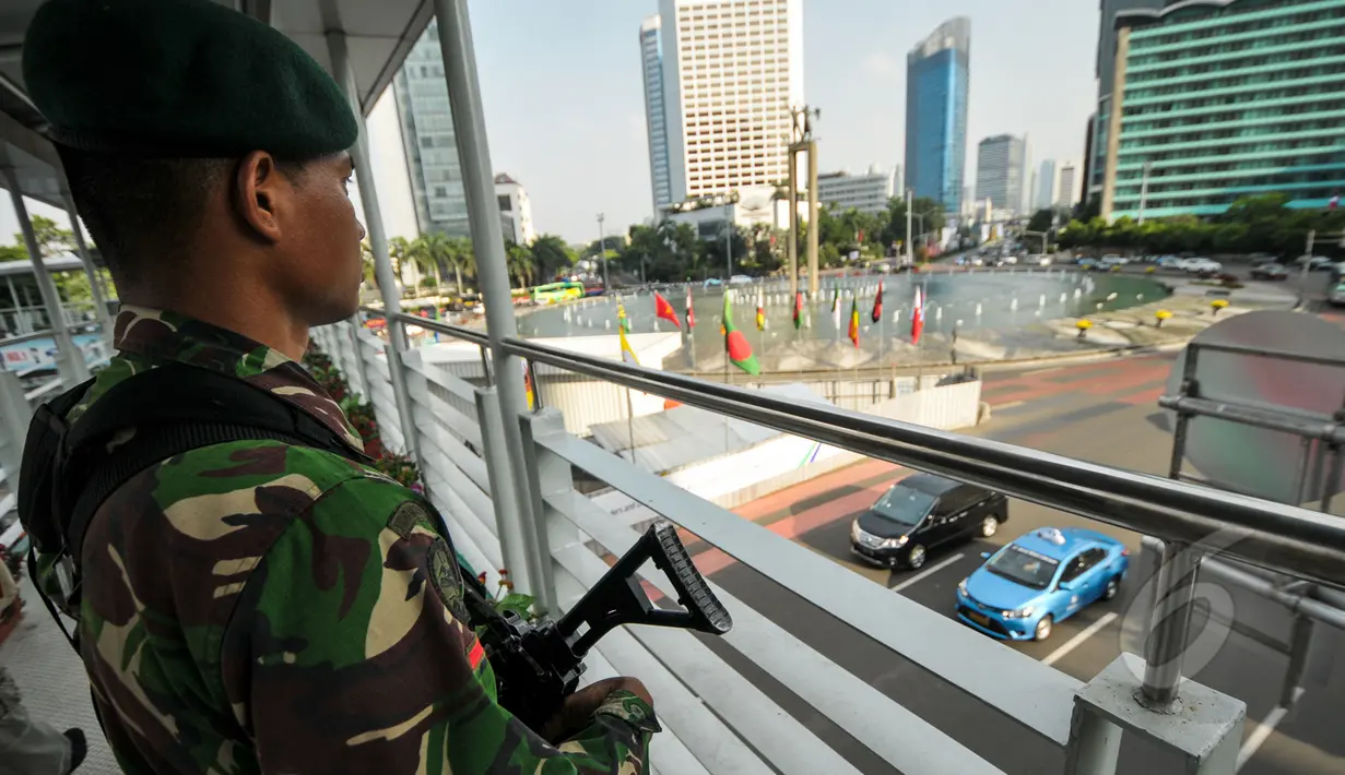 Seorang prajurit TNI memantau keamanan di kawasan Bundaran HI, Jakarta, Senin (20/4/2015). Pengamanan dilakukan untuk menjaga kelancaran KAA yang berlangsung 19-24 April 2015 di Jakarta dan Bandung. (Liputan6.com/Faizal Fanani)