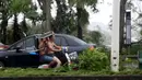Warga mengendarai sepeda motor usai Topan Mujigae menerjang Zhanjiang, Provinsi Guangdong, China, Minggu (4/10). Topan dengan kecepatan angin hingga 180 km per jam menghantam pantai selatan China dan menewaskan sedikitnya empat orang. (REUTERS/Stringer)