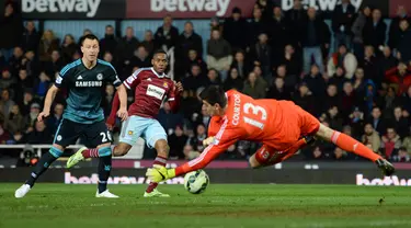 Kiper Chelsea, Thibaut Courtois saat menghalau bola tendangan penyerang West ham Diafra Sakho saat Laga Liga Premier Inggris di Stadion Boleyn Ground, Inggris, Rabu (4/3/2015). Chelsea menang 1-0 atas West ham. (Reuters/Tony O'Brien) 