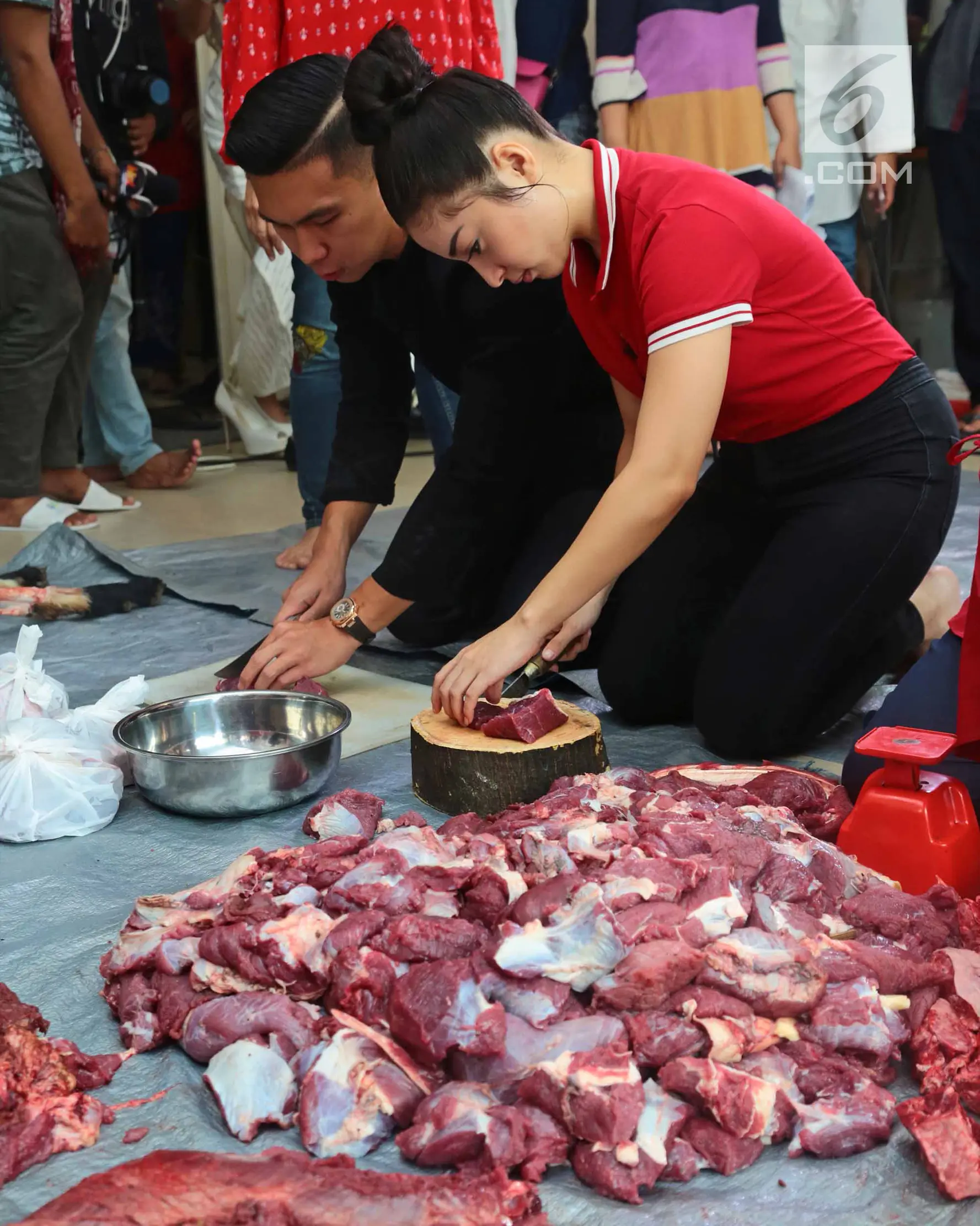 Aktris Nikity Willy didampingi kekasihnya, Indra Priawan Djokosoetono memotong daging kurban Idul Adha untuk dibagi bagikan di kediamannya Jatiwaringin, Jakarta (1/9). (Liputan6.com/Herman Zakharia)