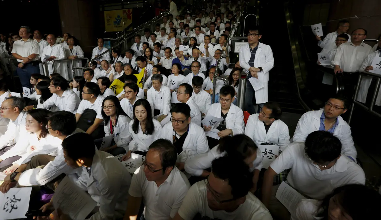 Ratusan dokter mendengarkan orasi saat aksi protes di dalam sebuah rumah sakit di Hong Kong, Rabu (21/10). Ratusan dokter umum tersebut menuntut kenaikan gaji sejalan dengan kenaikan upah pegawai negeri di kota itu. (REUTERS/Bobby Yip)