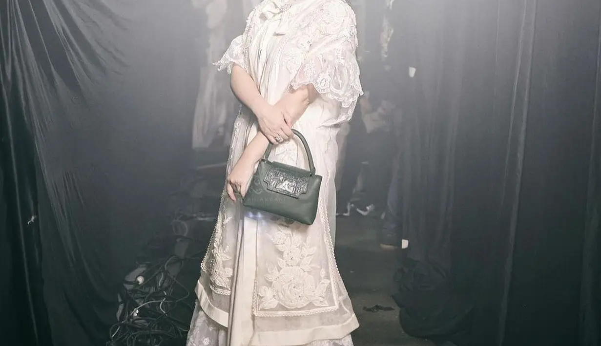 Di sini Nagita Slavina terlihat menawan dalam balutan busana serba putih. Sebuah dress putih yang super cantik dipadunya dengan alas kaki yang juga berwarna putih, dipadukan dengan handbag hijau yang kontras, namun manis. [Foto: Instagram/pecintaladygigi]