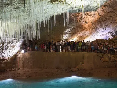 Pengunjung berada di dalam gua alam Choranche, di wilayah Vercors dekat Grenoble, Prancis (3/8). Sejak dimulainya gelombang panas, telah terjadi peningkatan setidaknya 10 persen jumlah pengunjung gua. (AFP Photo/Jean-Pierre Clatot)