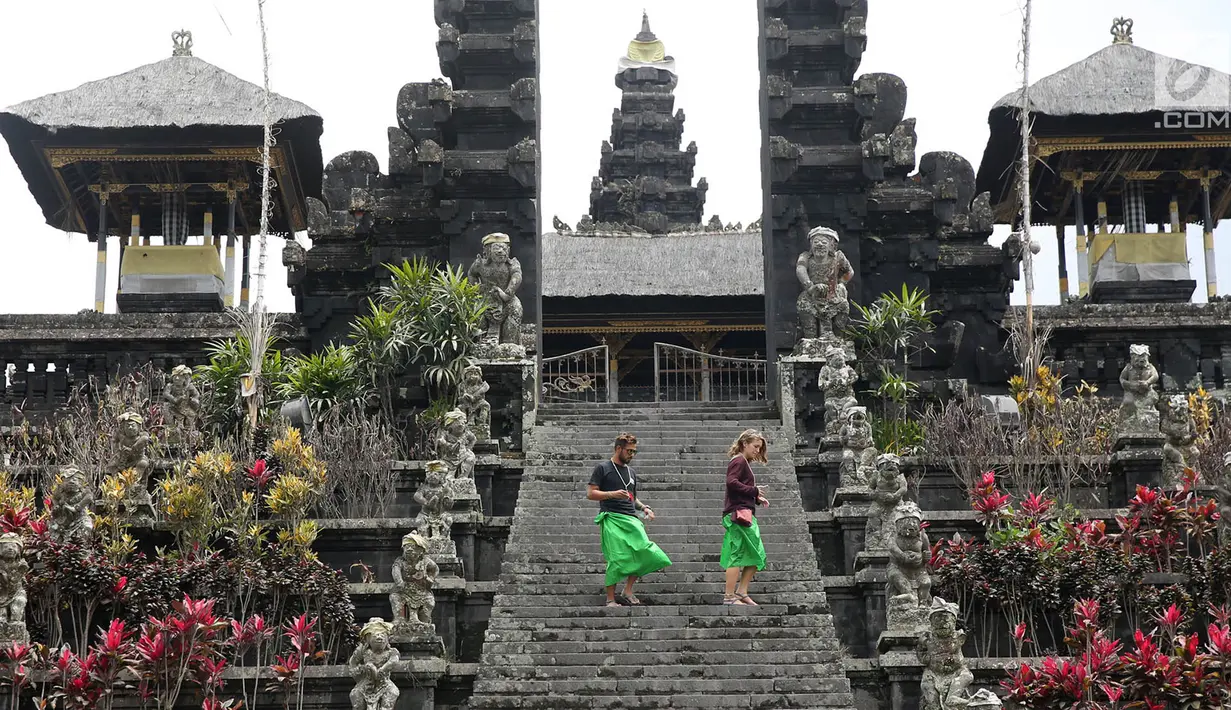 <p>Dua orang turis mengunjungi komplek Pura Besakih, Rendang, Bali, Minggu (3/12). Jika yang biasanya ramai aktivitas dan wisatawan, Komplek Pura Besakih sepi karena masuk dalam zona Kawasan Rawan Bencana (KRB) 3 Gunung Agung.(Liputan6.com/Immanuel Antonius)</p>