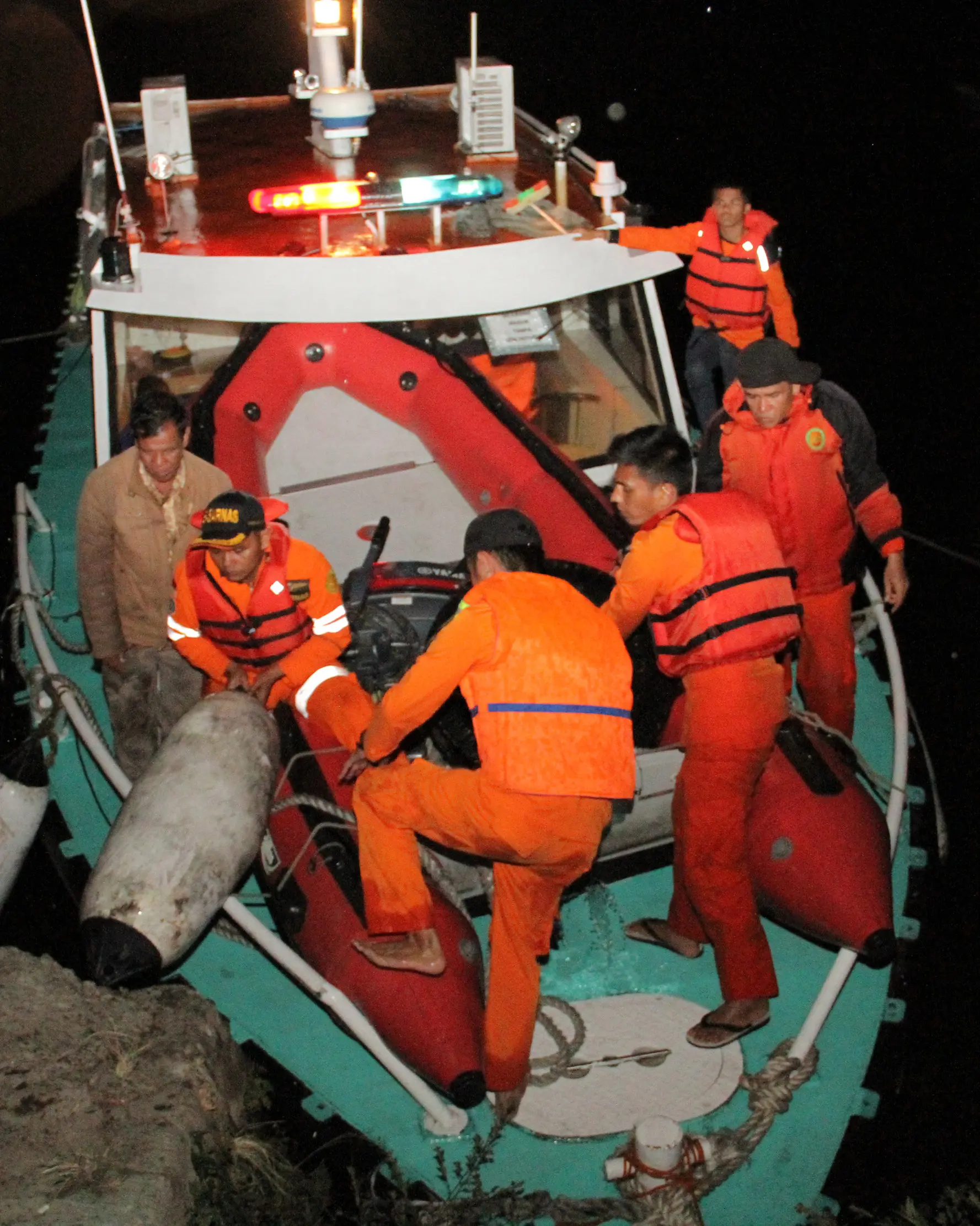 Tim penyelamat kembali ke pelabuhan usai pencarian korban hilang KM Sinar Bangun yang tenggelam di Danau Toba, Sumatera Utara, Senin (18/6). Cuaca buruk memaksa tim penyelamat sempat menunda pencarian. (AFP Photo/Lazuardy Fahmi)