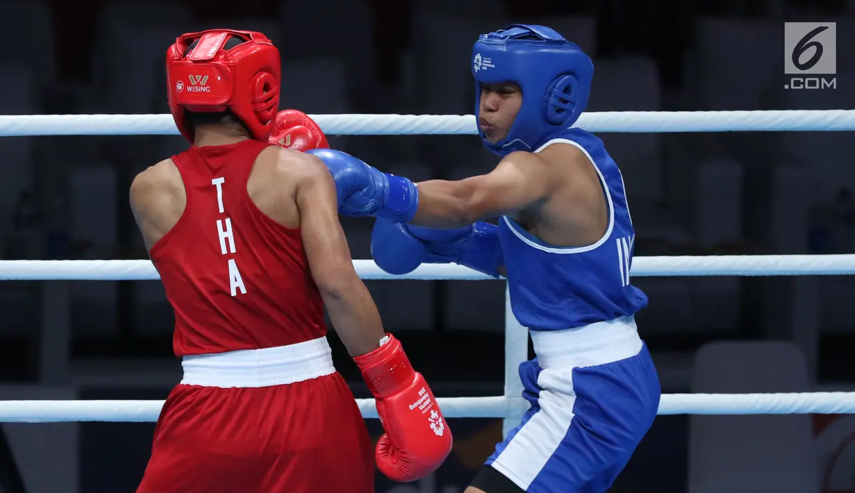 Petinju putri Indonesia, Huswatun Hasanah (kaus biru) melempaskan pukulan ke arah Sudaporn Seesondee (Thailand) pada semifinal kelas ringan 60kg putri Asian Games 2018 di JIEXPO Kemayoran, Jumat (31/8). Huswatun kalah. (Liputan6.com/Helmi Fithriansyah)