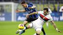Pemain Inter Milan, Sebastiano Esposito, berebut bola dengan pemain Genoa, Ivan Radovanovic, pada laga Serie A 2019 di Stadion San Siro, Sabtu (21/12). Inter Milan menang 4-0 atas Genoa. (AP/Luca Bruno)
